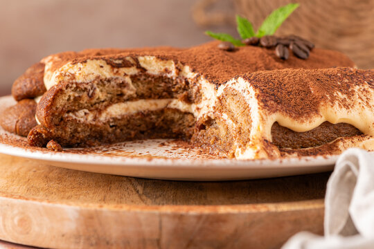 Delicious tiramisu cake on a plate with coffee