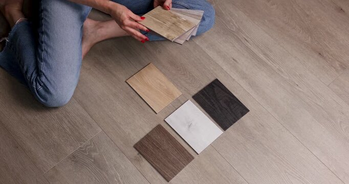 Woman choosing wood flooring samples for home renovation and interior design