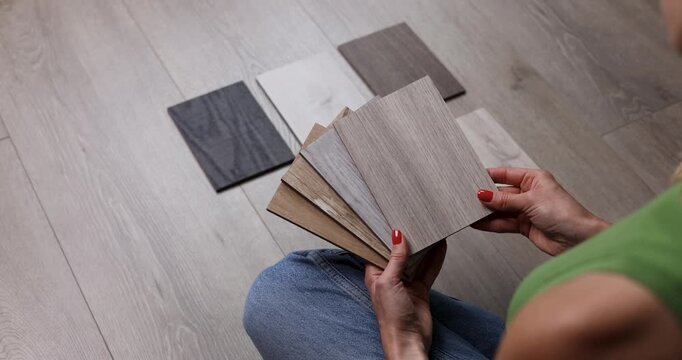 Woman choosing wood flooring samples for home renovation and interior design