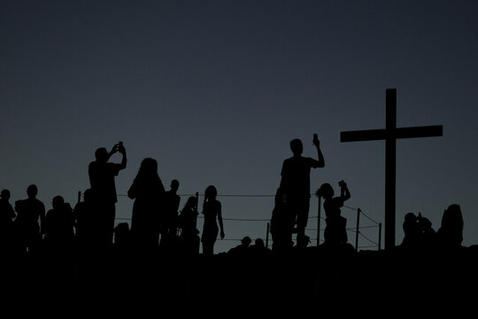 Visitors silhouetted beside the cross on Areopagus Hill in Athens, Greece, the traditional location where the Apostle Paul delivered his famous sermon.