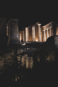 A close view of the illuminated Acropolis in Athens, Greece, highlighting ancient columns and stone architecture dramatically lit against the night sky.