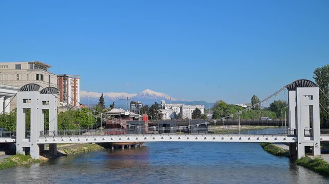 Skopje cityscape with the Vardar river and snowy mountains