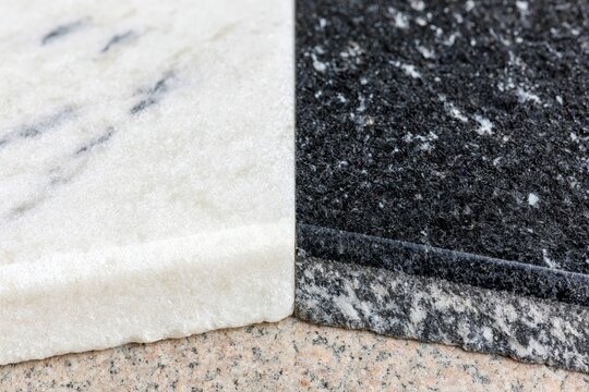 Close-up macro view of contrasting white marble and black granite stone samples side-by-side.