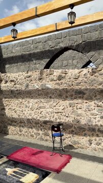 Prayer rugs under stone arches at the historic open-air Masjid Bani Anif in Madinah.