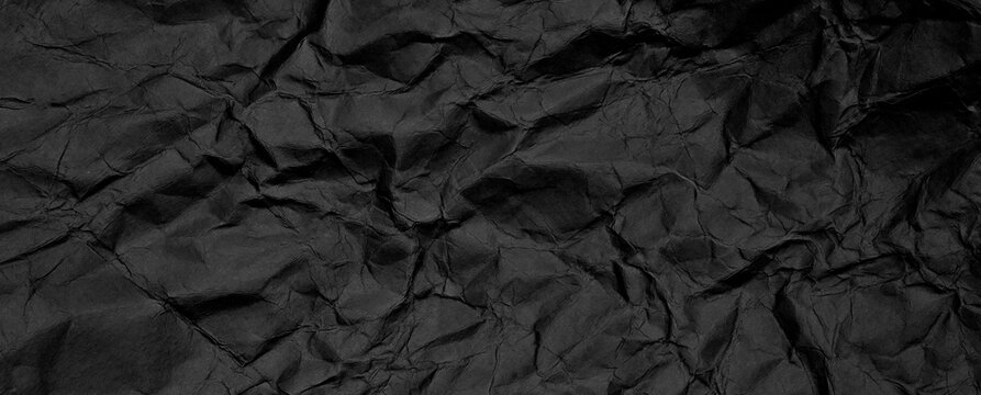 Texture di carta nera stropicciata con pieghe irregolari e superficie grunge