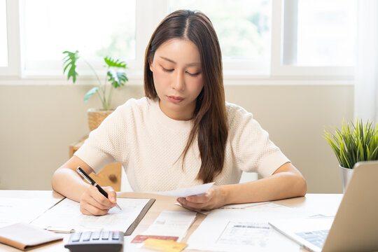 Deduction planning, debt asian young woman calculating money balance of finance from bill and income, cost budget expenses for pay money form personal individual on table at home. Financial concept.