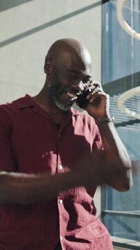 Laughing, business or black man with phone call for discussion or proposal in office building. Happy, businessman or smile with smartphone for friendly chat, funny humor or communication in workplace