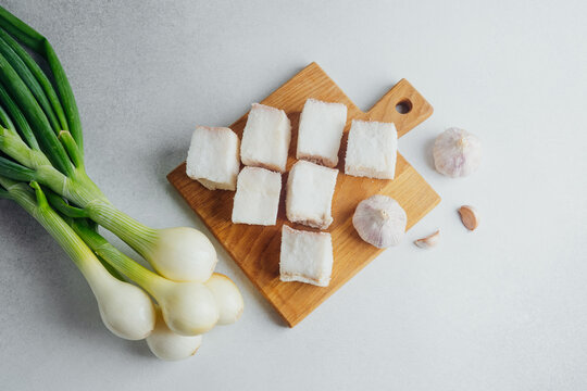 Diced fatback with green onions and garlic on a cutting board