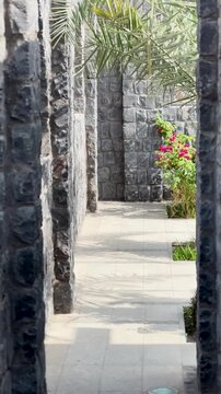 Walking path along stone walls and lattice windows at historic Masjid Bani Anif.