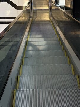 Escalator steps leading down in indoor shopping center  