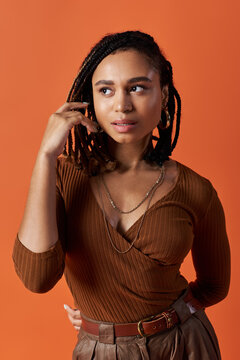 A young woman in chic attire stands confidently, showcasing her unique style and grace.