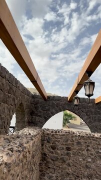 Stone arches, wooden beams, and lanterns at historic Masjid Bani Anif in Medina.