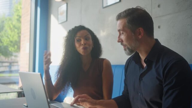 Business man and woman developing AI startup project using laptop restaurant