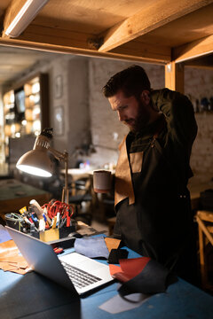 Craftsman with hot drink scratching head and thinking