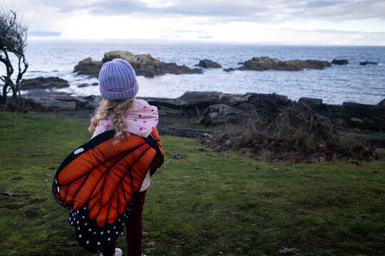 Toddler wearing butterfly wings outside