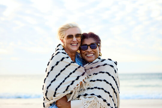 Friends Smile Together on the Beach at Sunset