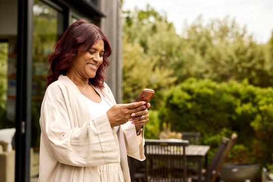 Woman texting by Phone in a Garden