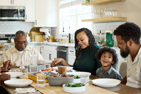 Family saying a blessing before starting to eat