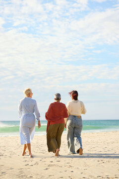 Three women Walk Along the Beach With Waves