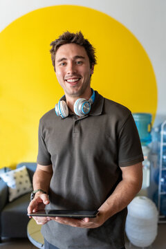 Smiling man holding tablet in a modern office