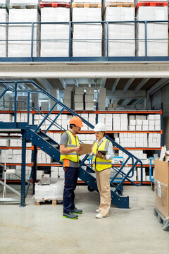 Warehouse workers discussing logistics and inventory management