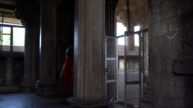Indian woman in colorful saree walks around and explore Khajuraho Temple, UNESCO World Heritage Site, India.