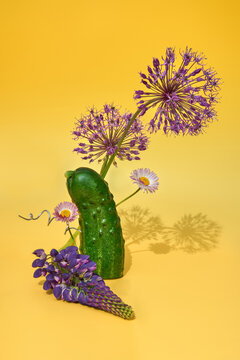 Still life with a Cucumber and Flowers on a Yellow Background