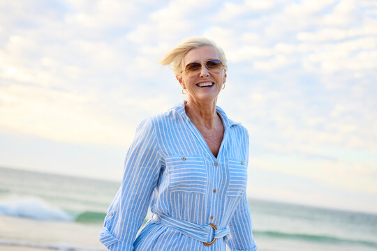 Smiling Woman Walks on Beach During Daylight