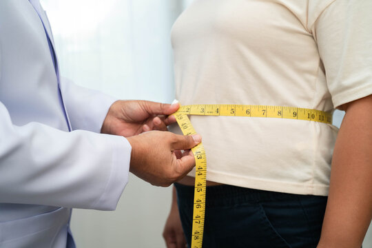 Asian woman with fat belly big size overweight and obesity with measure tape.