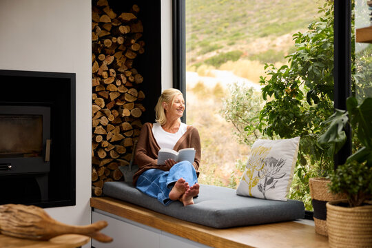 Woman Reads by the Window in luxury house