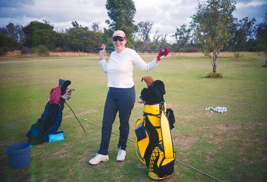 Woman Practicing Golf at a Driving Range in the Afternoon