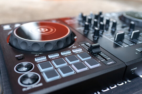  professional DJ controller with illuminated jog wheel, performance pads, mixer faders, audio controls. Modern music production, live performance, nightclub entertainment, electronic sound technology