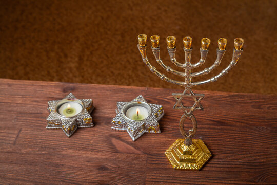 Shabbat candles in Star of David candlesticks and a menorah on the table