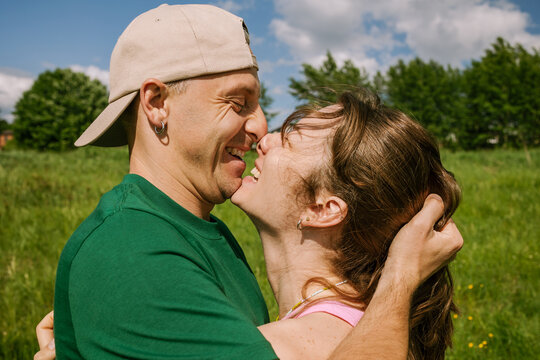 A man and a woman laugh in each other's arms.