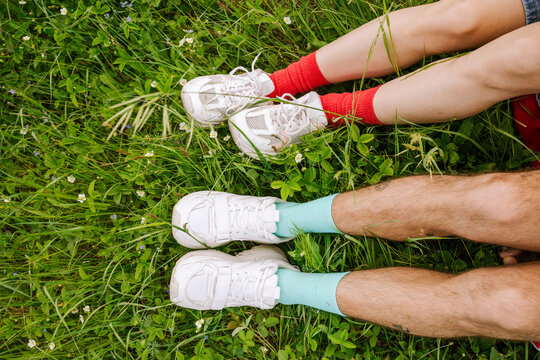 Feet of a man and a woman in bright socks on the grass