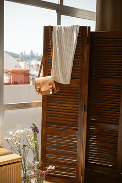 Clothes and accessories hanging from a folding screen