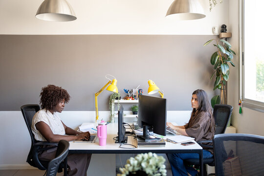 Diverse business women collaborating in bright modern office