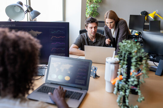 Colleagues collaborating on business data in modern office