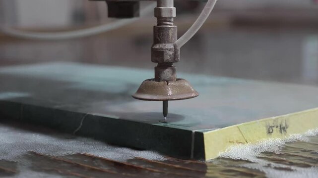 Heavy machinery cutting large marble block in natural stone factory production line