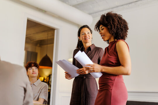 Professionals discussing documents during a business meeting