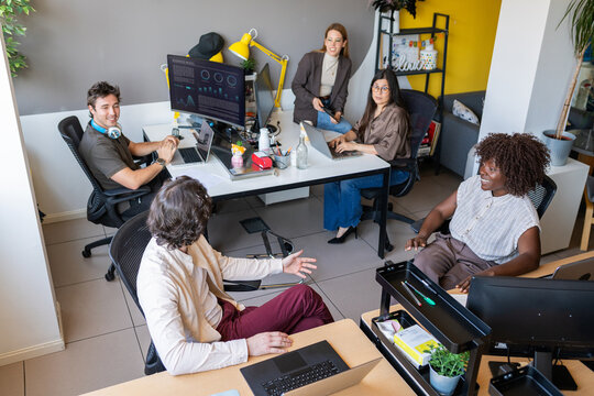 Coworkers collaborating and discussing in modern office