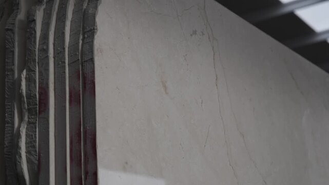 Heavy machinery cutting large marble block in natural stone factory production line