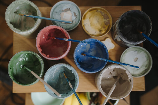Close up of artisan hands molding raw clay at a messy workshop table