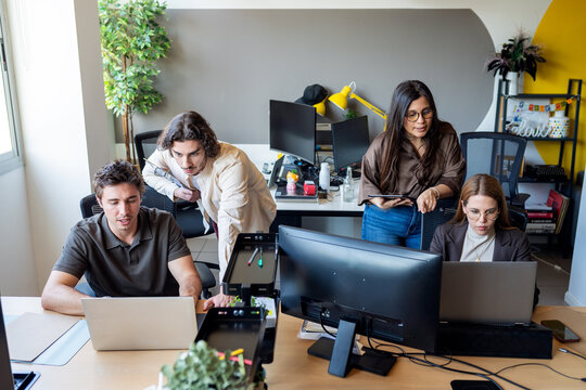 Business people collaborating on computers in modern office