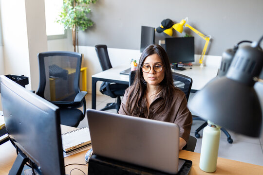 Businesswoman focused working on laptop in modern office