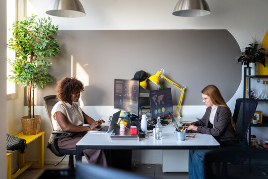 Diverse women collaborating on data analytics in modern office