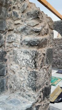 Pan from prayer mats inside historic Masjid Bani Anif to its exterior stone walls.