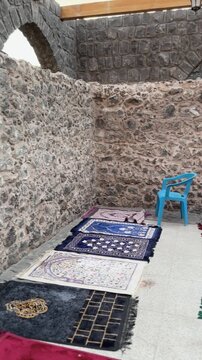 Prayer mats arranged in the historic stone interior of Masjid Bani Anif, Madinah.