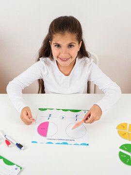 Young Girl Learning Fractions with Educational Math Manipulatives at White Desk