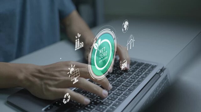 Net Zero emission concept. Person using laptop with sustainability and carbon reduction icons, climate action, clean energy and environmental responsibility.